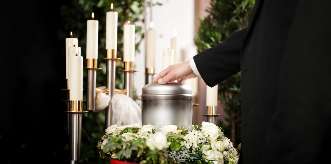 Ceremonia funeraria con urna y elementos conmemorativos para explicar las diferencias entre entierro y cremación